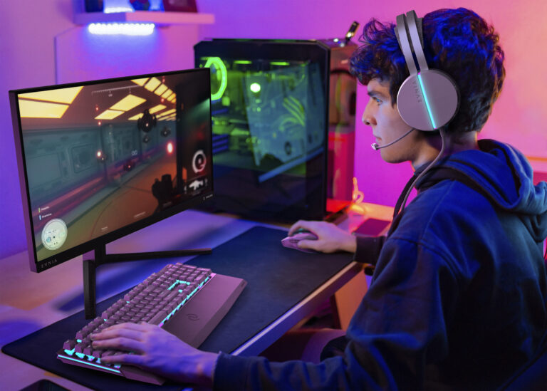 Caucasian young teenager plays computer in his room with colored lights and looks at the screen concentrated